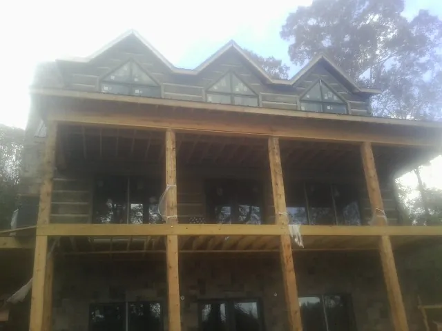 Dormers and porch framing on a large log home under construction — Roof Coating work by our crew in Tellico Plains