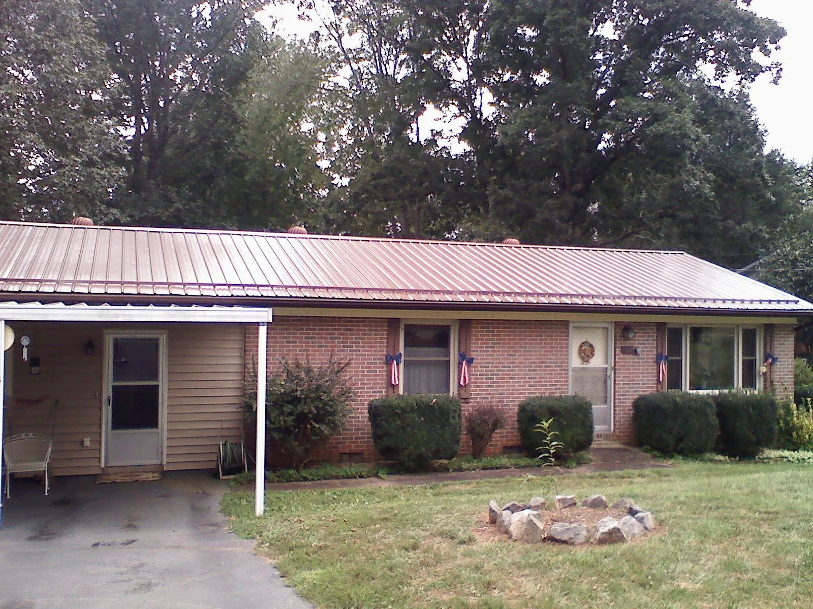 Bronze metal roof and carport on a brick ranch home — Roof Repair work by our crew in Tellico Plains